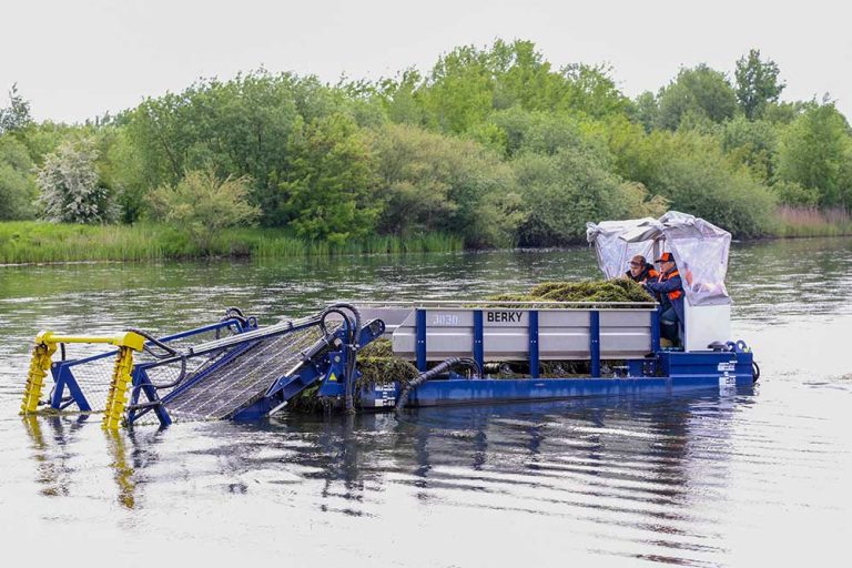 MINSK, BELARUS - 1 OCTOBER, 2020: mowing algae in the river in the city.
